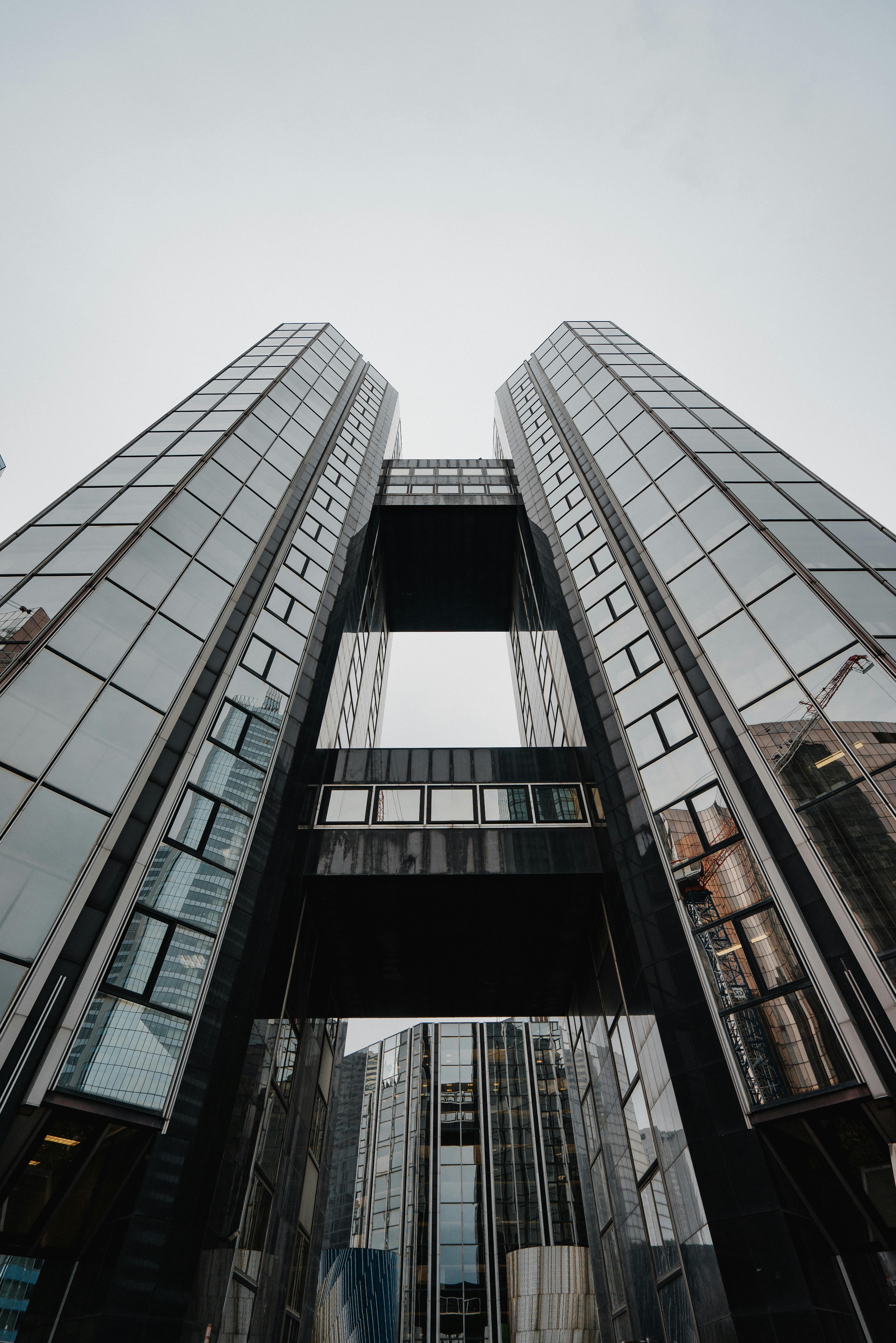 从下方拍摄的现代摩天大楼反光玻璃立面，展现出城市建筑的惊人景色