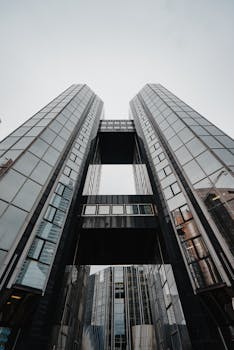 从下方拍摄的现代摩天大楼反光玻璃立面，展现出城市建筑的惊人景色