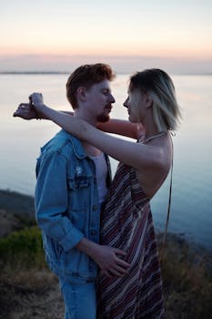 一对夫妇在海边拥抱，于浪漫的日落时分捕捉亲密的甜蜜时刻