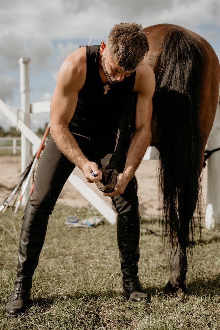 Man Removing A Horse Shoe