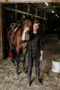 Man Standing in Barn Hugging His Horse