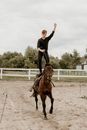 A Man Doing Stunts While Riding a Brown Horse