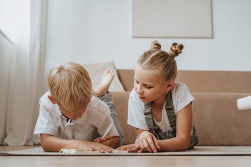 Free Two children focusing on homework together indoors, fostering sibling togetherness. Stock Photo