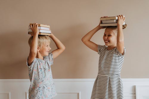 Brother and Sister With Books on Their Heads