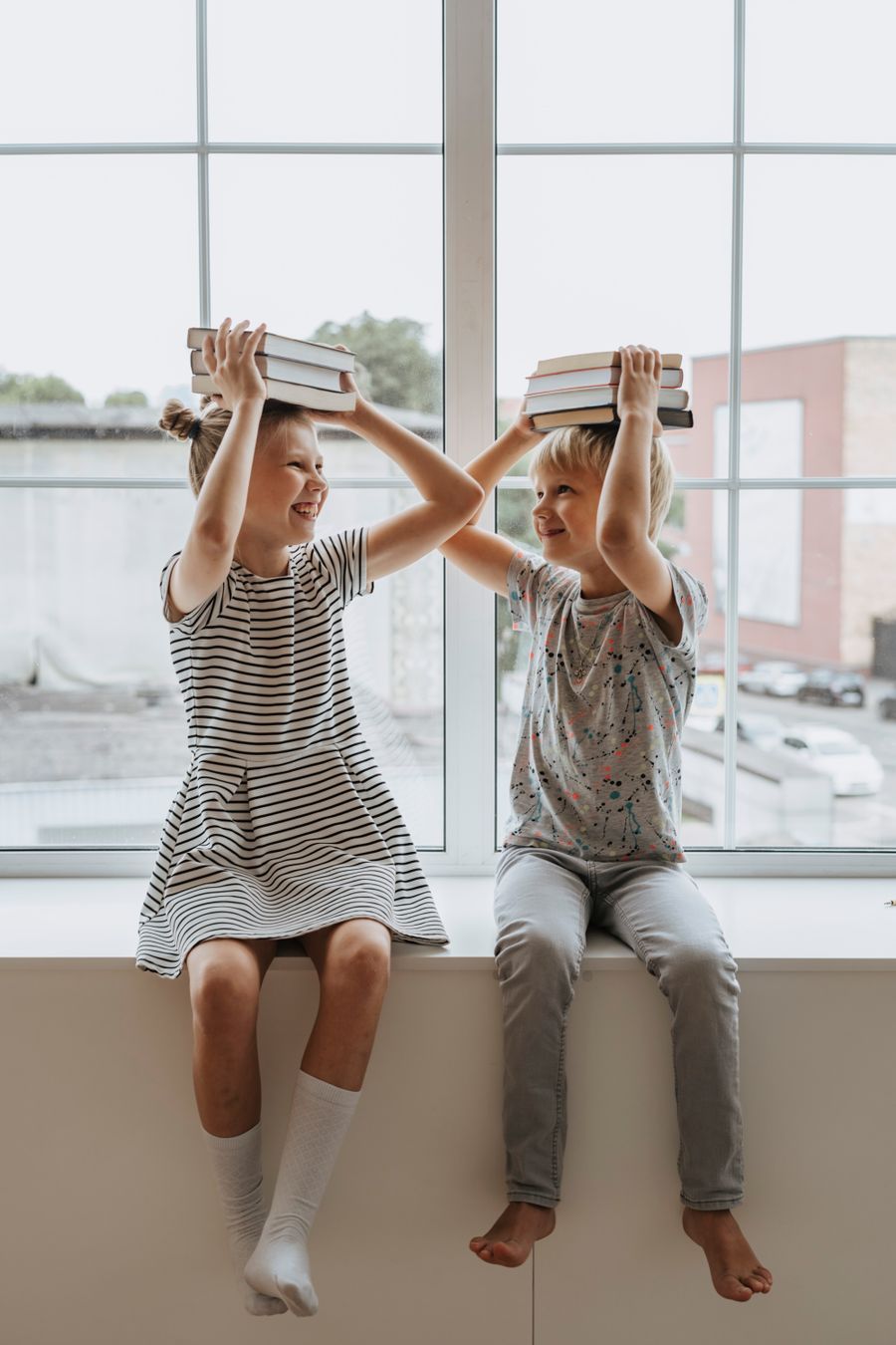 Brother and sister playing together with books, enjoying learning