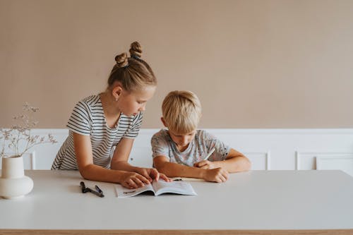 Little Girl Helping her Brother with Homework