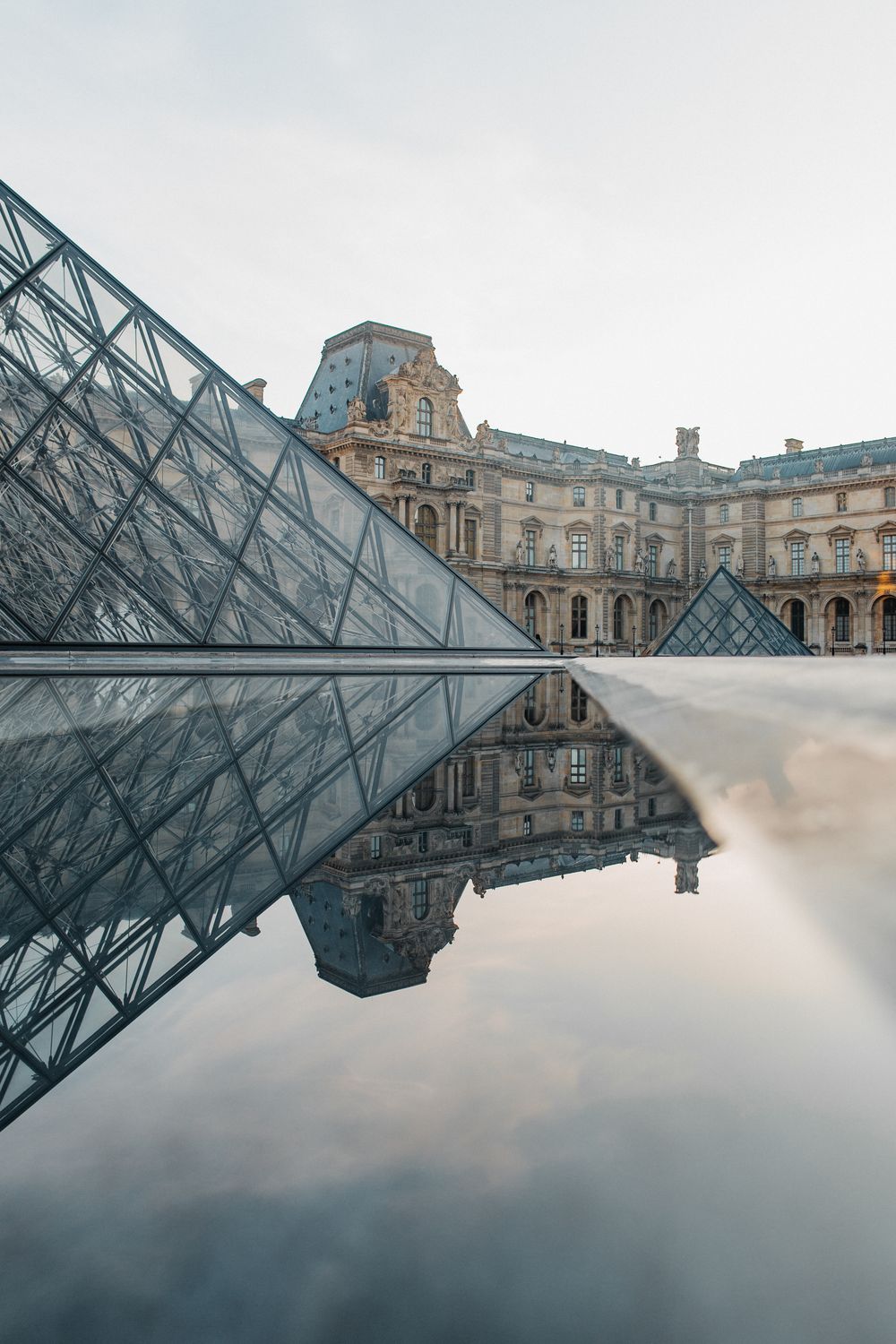 Pirámide del Louvre reflejada al atardecer en París
