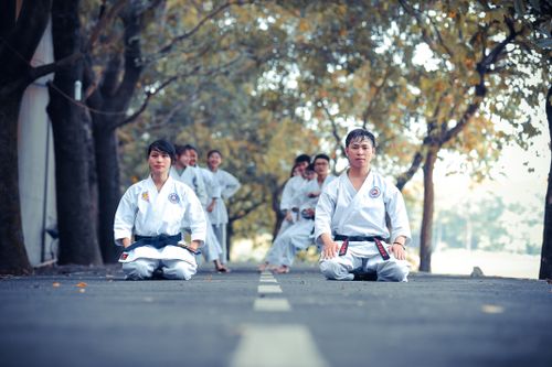 Free Karate practitioners performing martial arts training outdoors on a sunny day. Stock Photo
