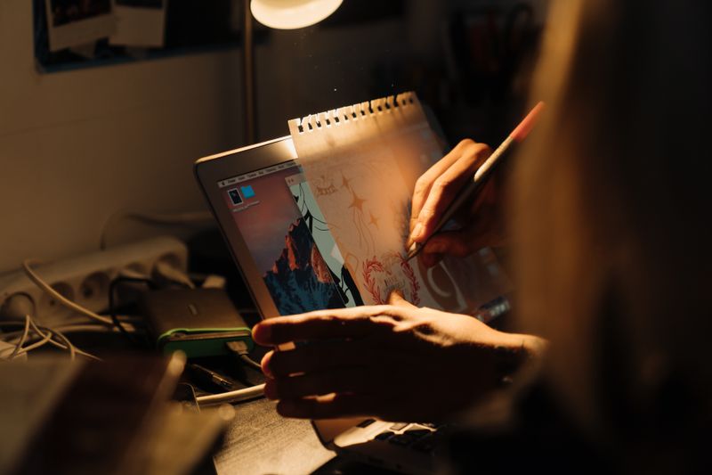 Designer sketching a layout under focused light