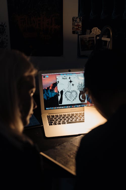 Wanita Berkemeja Hitam Duduk Di Depan Macbook Pro