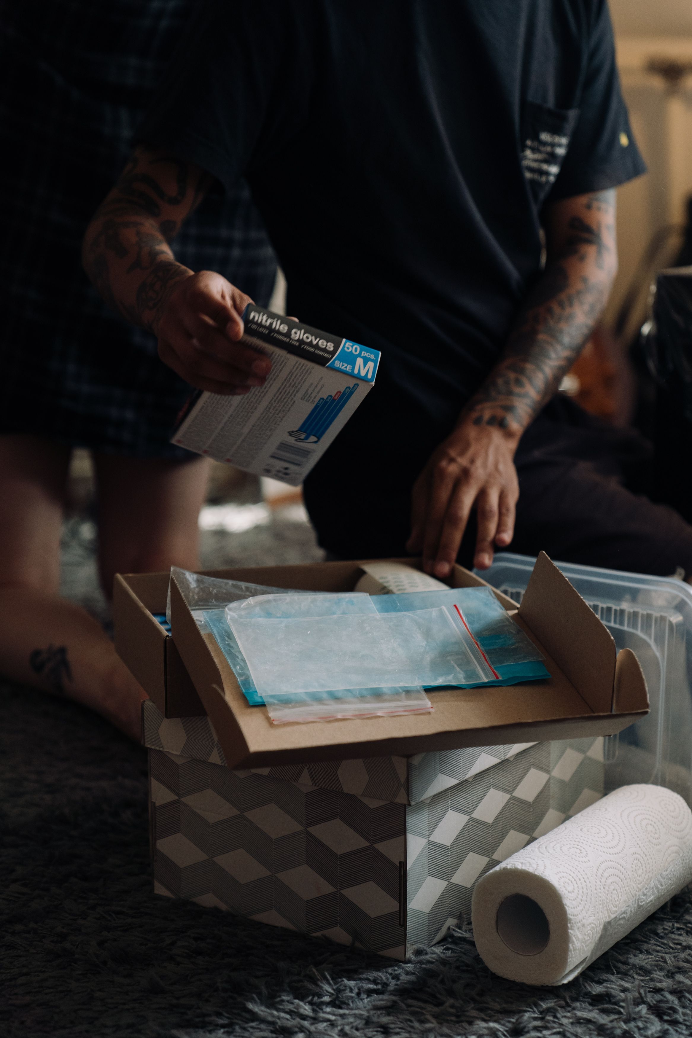 Tattoo artist organizing nitrile gloves and supplies, ready for a tattoo session in the studio.
