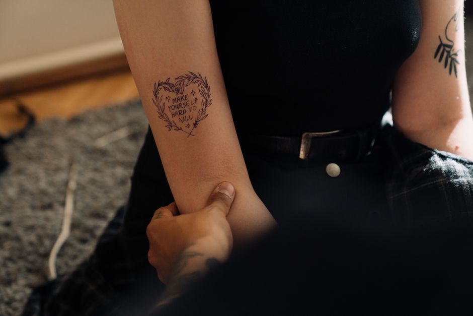 Tattoo Artist mapping out tattoo placement on a client's arm before starting Tattoo Artist mapping out tattoo placement on a client's arm before starting