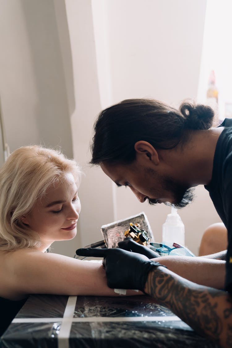 A Woman Getting A Tattoo On Her Arm