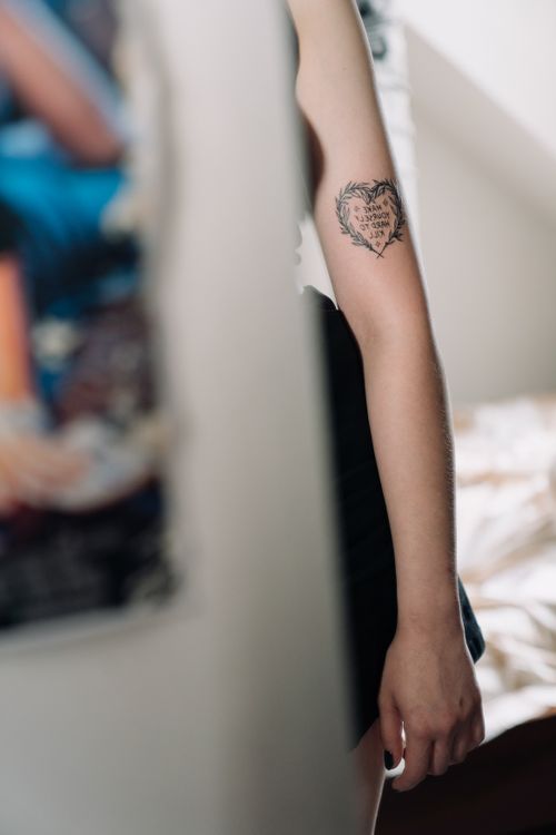 Free Close-up of a person's arm with a heart tattoo in a minimalist indoor environment. Stock Photo