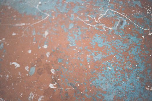 Close-up of a rusty surface with blue and white paint patterns.