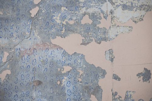 Free Close-up of distressed peeling wallpaper with vintage blue floral patterns creating a rough texture. Stock Photo
