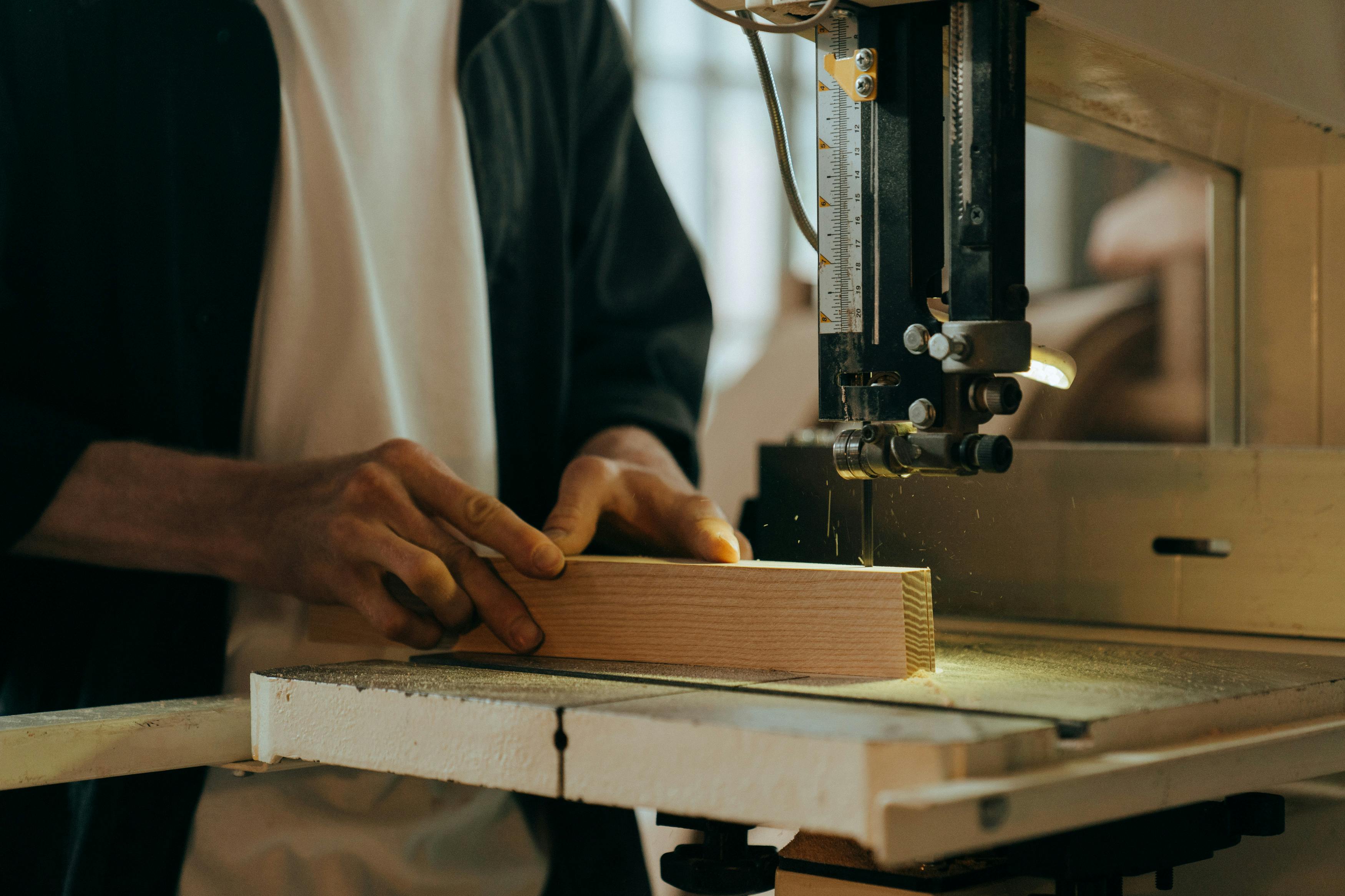 person in white long sleeve shirt using black sewing machine