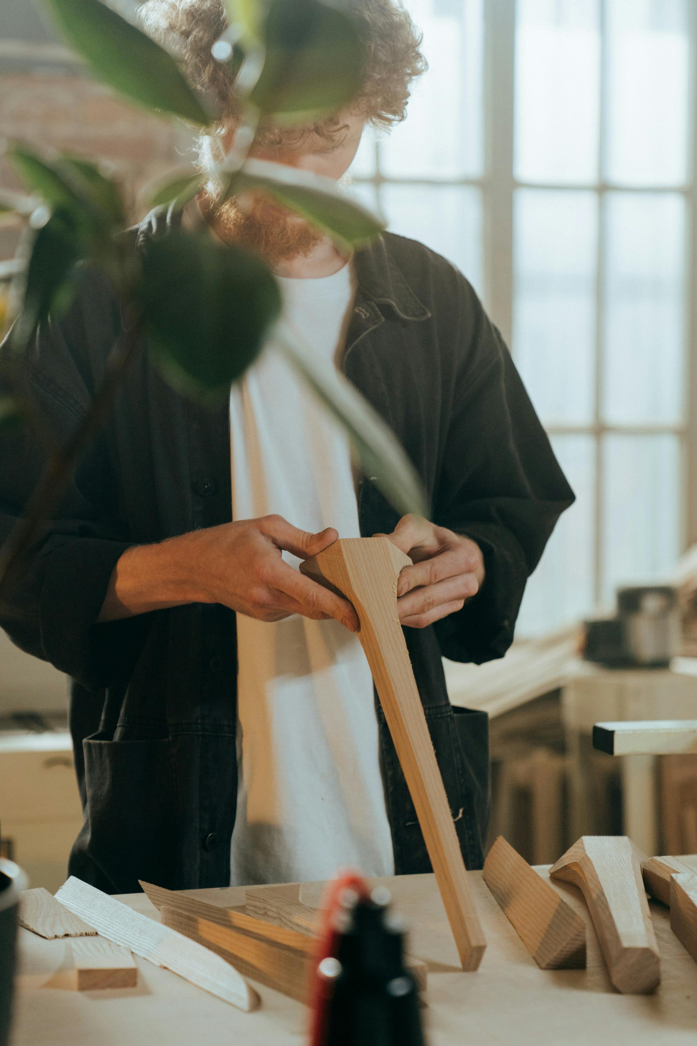 man in black long sleeve shirt holding brown wooden stick