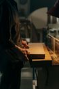 Person in Black Jacket Holding Brown Wooden Table