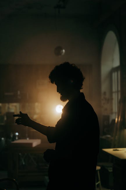 A craftsman silhouette in a dimly lit workshop, exuding a moody and artistic vibe.