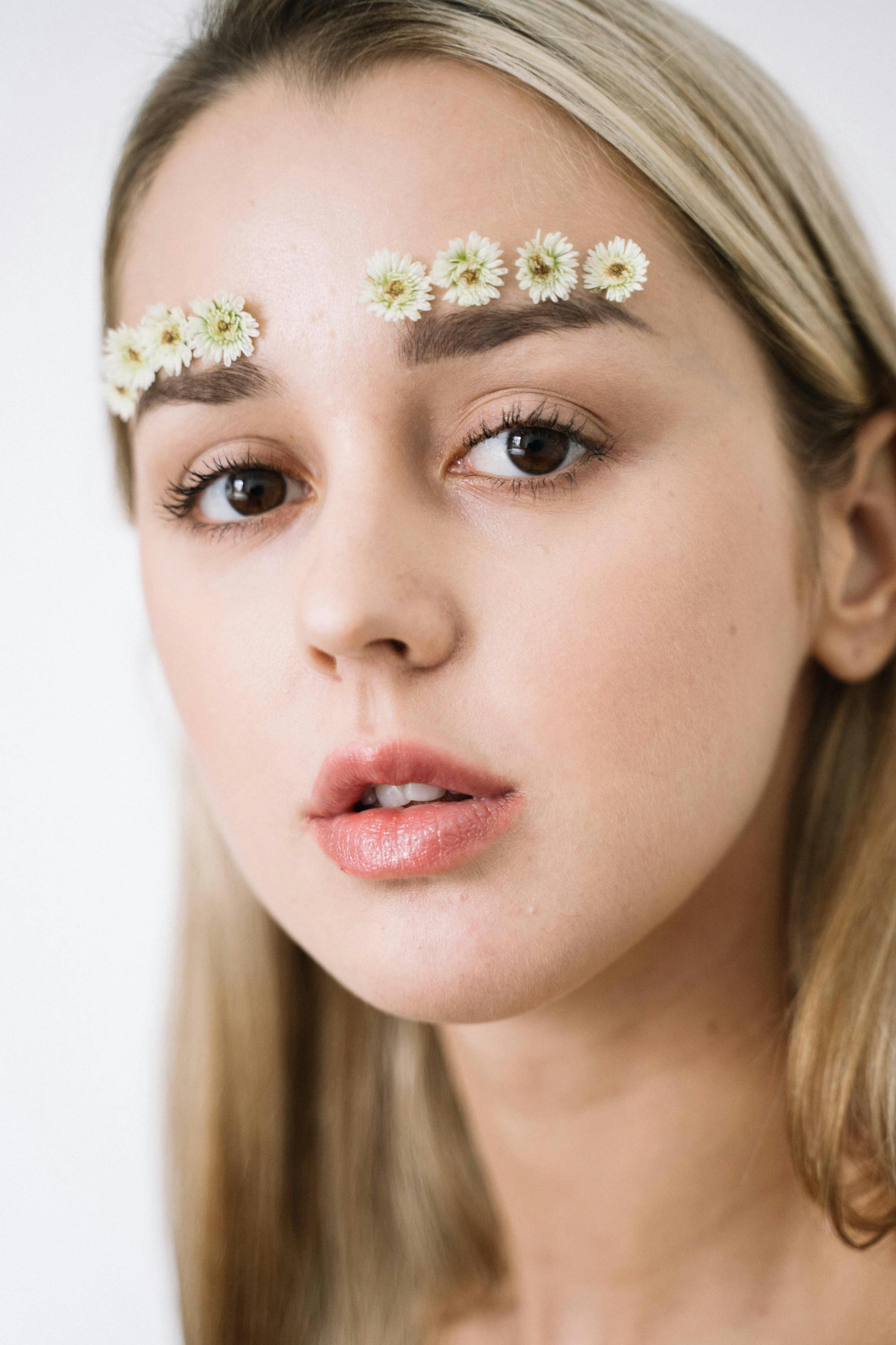 创意时尚镜头下的女性特写肖像，眉毛上点缀着花朵