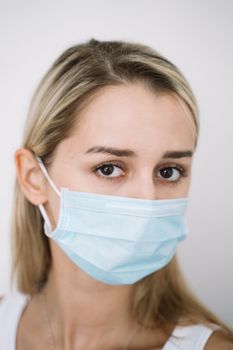 一名女子戴着蓝色口罩的特写肖像，强调了安全与健康