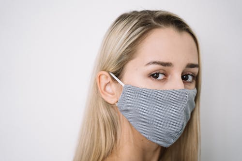 Free Close-Up Shot of a Woman with Face Mask Looking at Camera Stock Photo