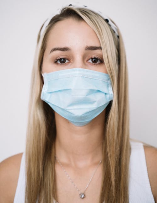 Free Close-Up Shot of a Woman with Face Mask Looking at Camera Stock Photo