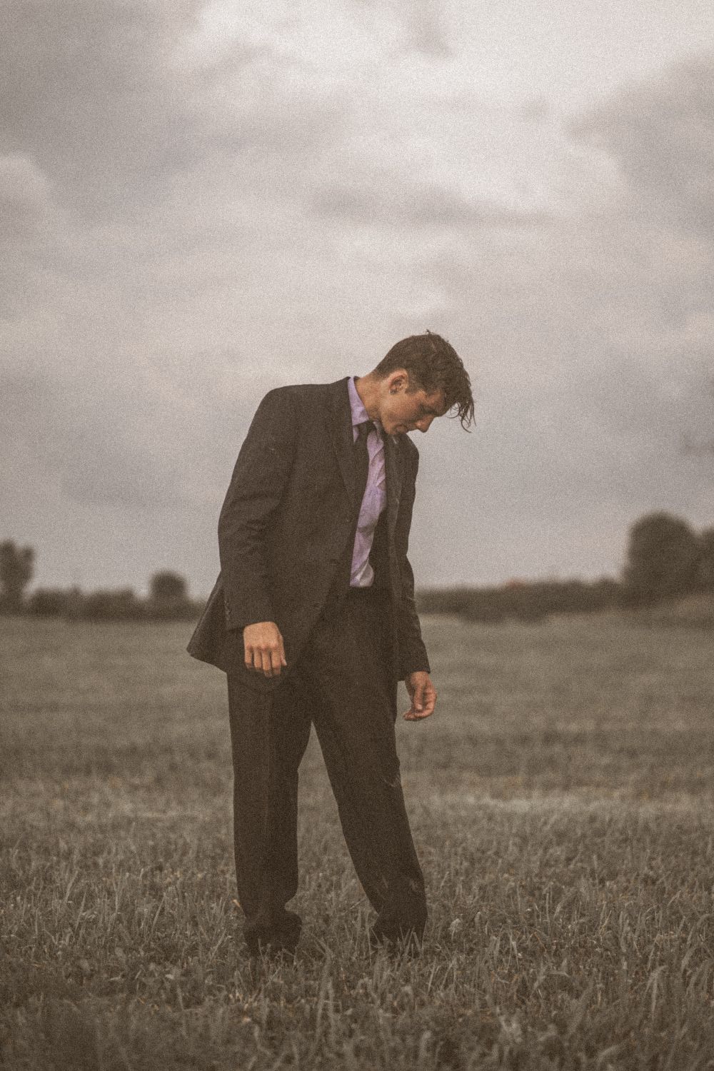 A Man in Black Suit Standing on the Grass Field · Free Stock Photo