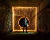 Man standing against lines of light in circle from fire swing