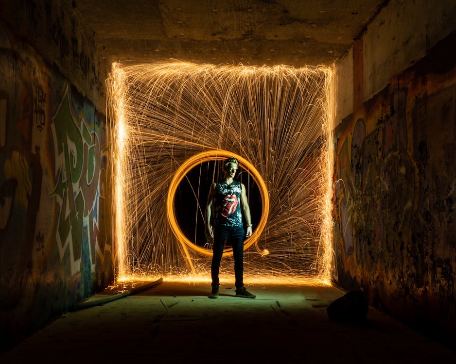 Free Man standing against lines of light in circle from fire swing Stock Photo