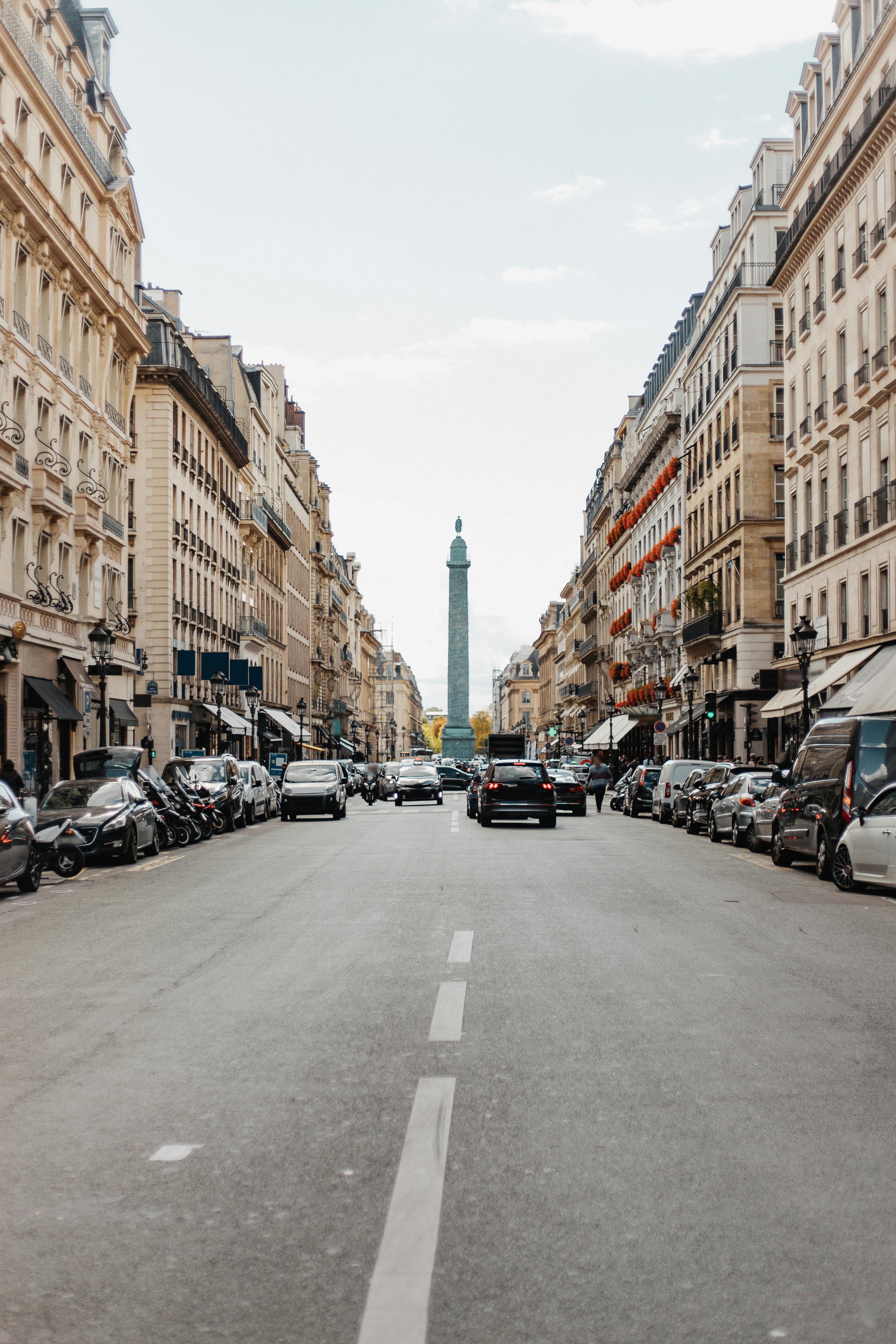 沿着熙熙攘攘的巴黎街道，可以看到周围环绕着经典建筑的旺多姆柱