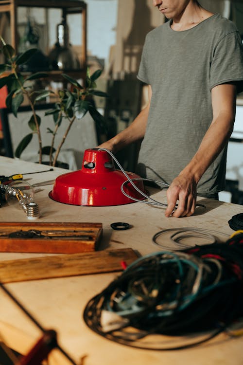 Man in Gray Crew Neck T-shirt Holding Red and Silver Power Tool