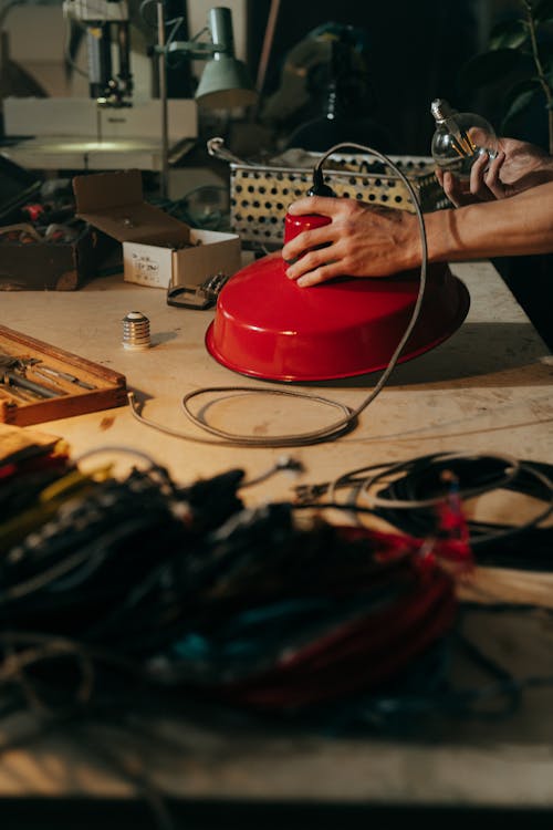 Person Holding Red Round Plastic Container