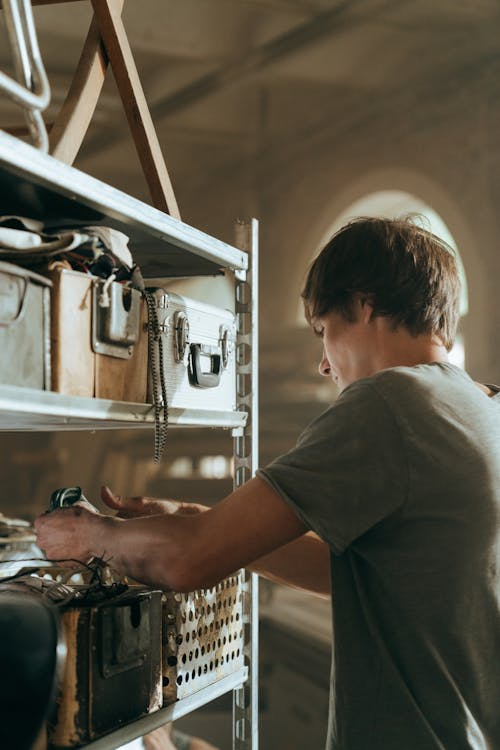 Man in Grey T-shirt Holding Black Metal Tool