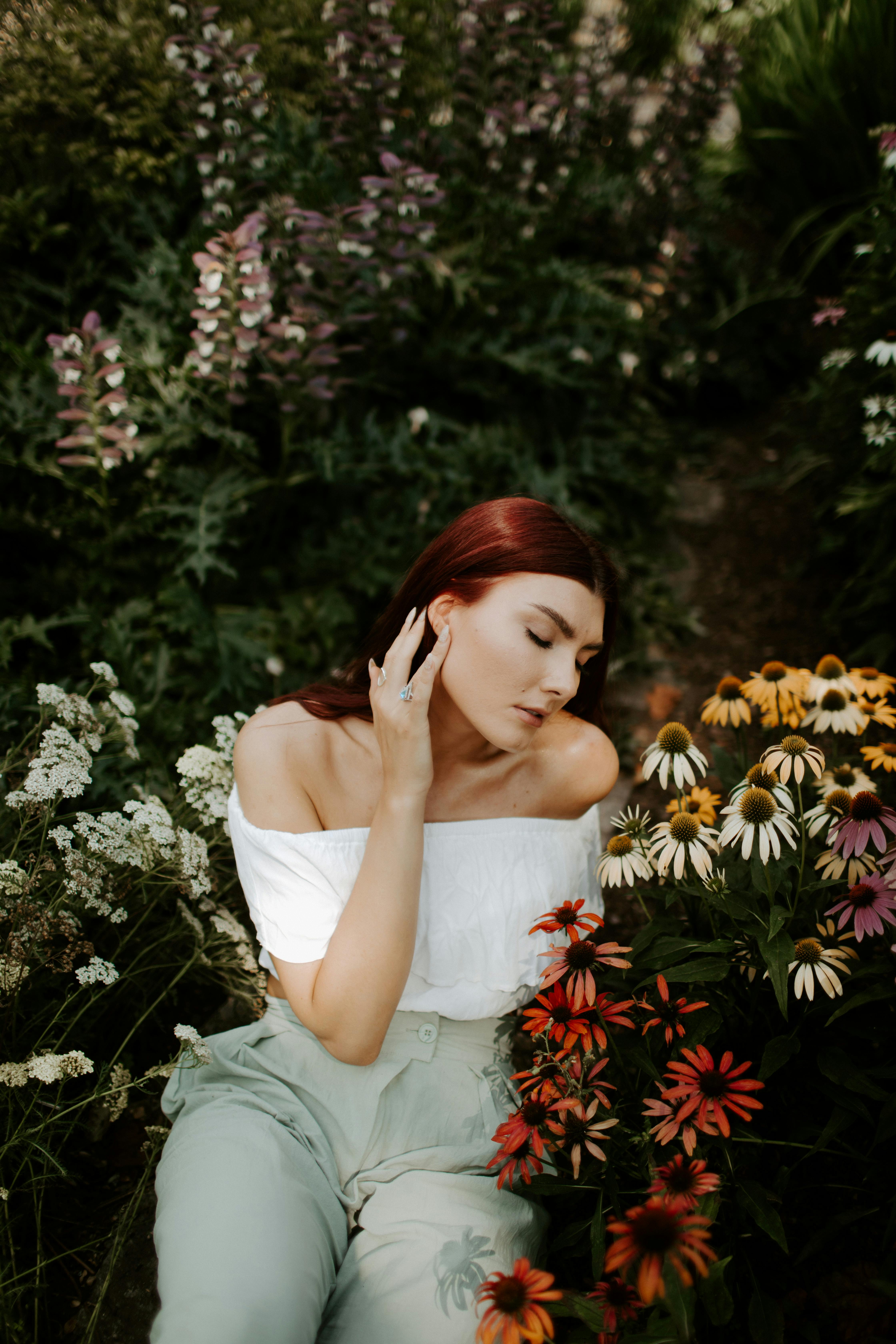 一位优雅的女性身着露肩装，肩部被五颜六色的花园花朵环绕，散发着宁静与美丽