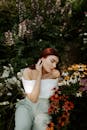 一位优雅的女性身着露肩装，肩部被五颜六色的花园花朵环绕，散发着宁静与美丽