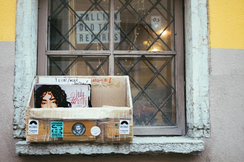 A Cardboard Box with Magazines on a Windowsill