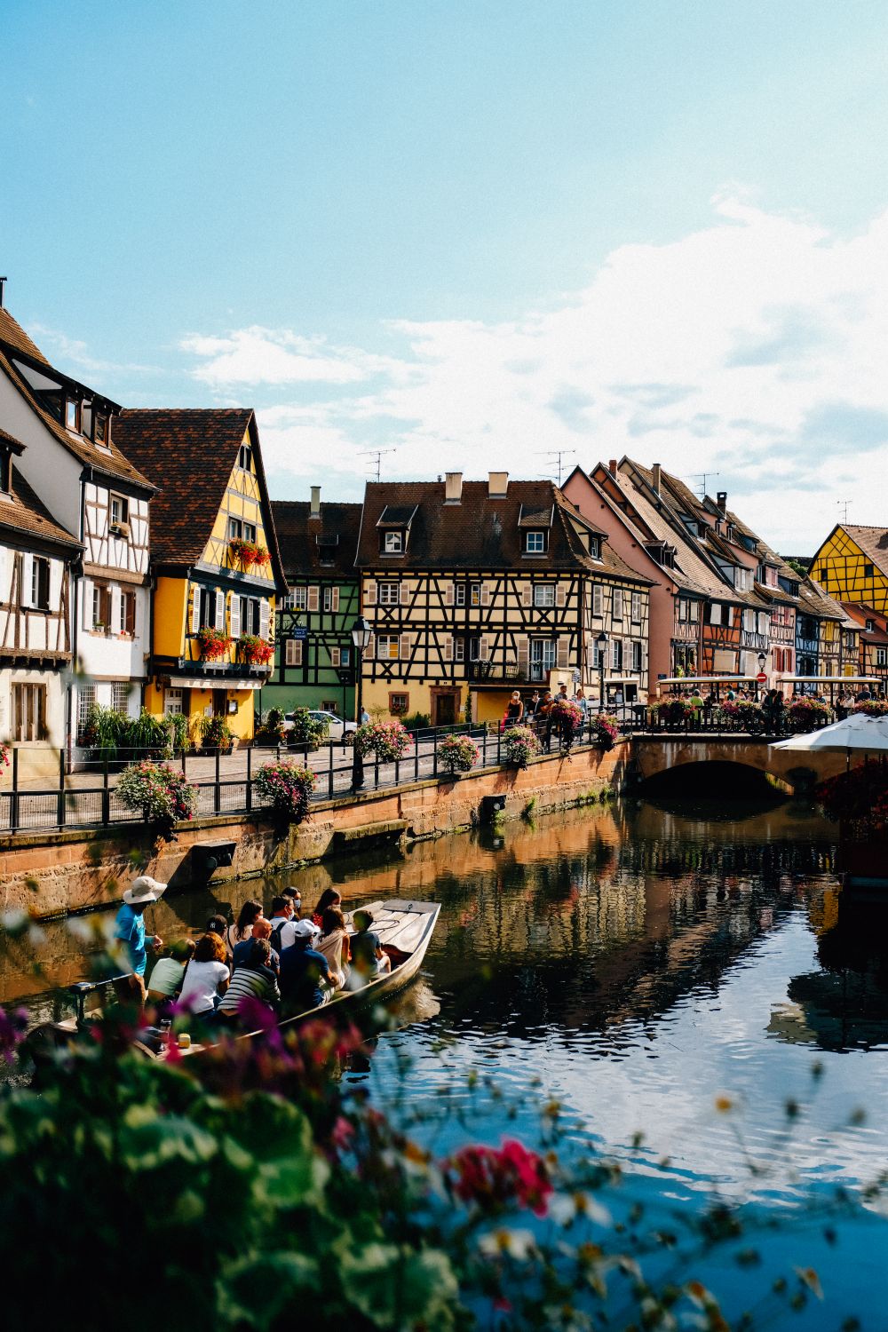 Little Venice din Colmar, cu case colorate din lemn de-a lungul canalului și o barcă de plimbare