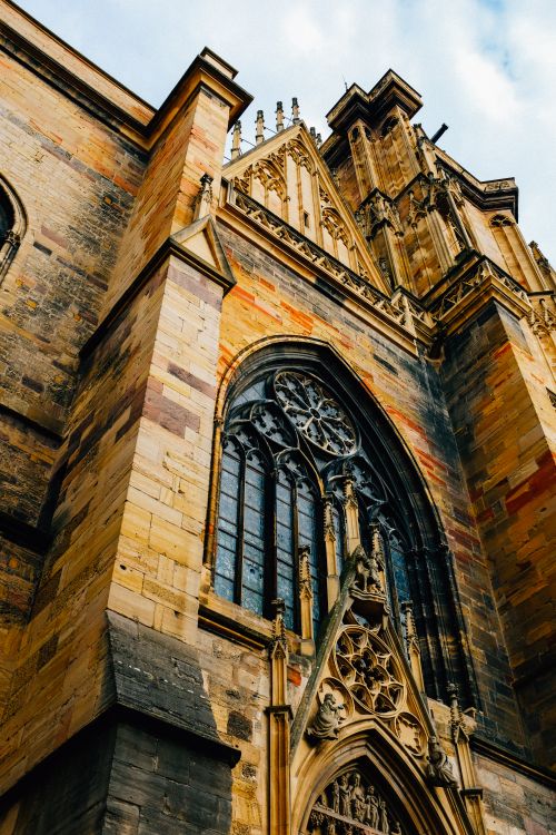 Free From below exterior of Saint Martin aged stone church with ornamental elements placed on street n city of Colmar in France Stock Photo