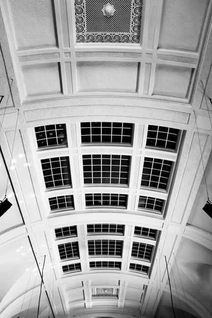 From below of massive round shaped ceiling with square shaped windows in old building