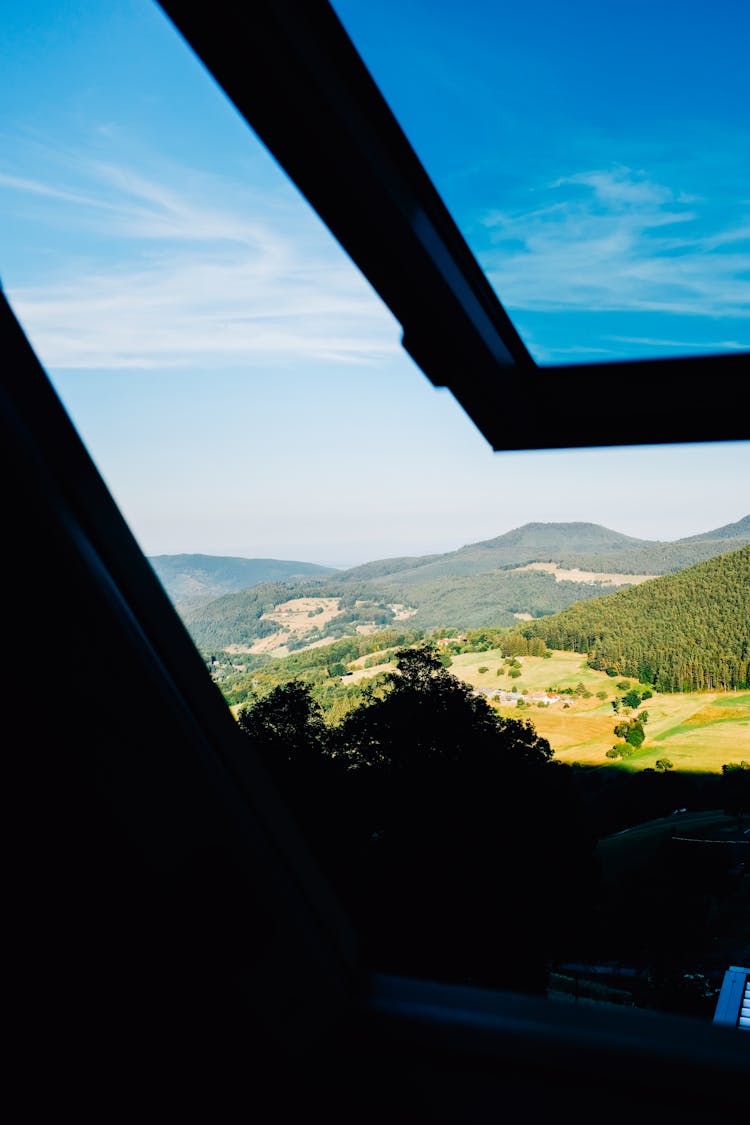 Open Window View Of Mountains With Forest And Fields