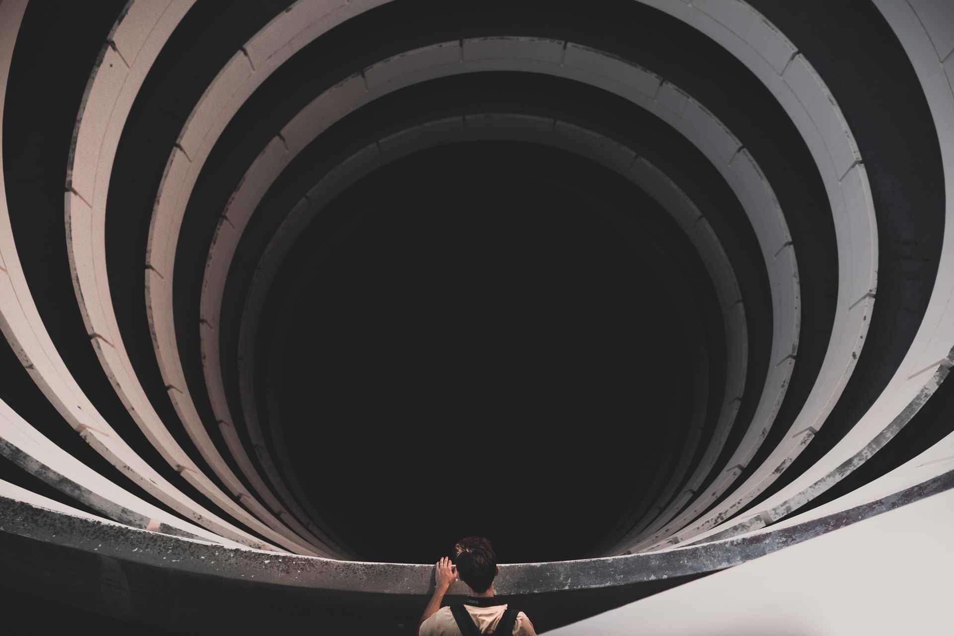 An intriguing view of a spiral tunnel with a person looking inside, suggesting depth and mystery.