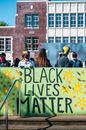 Protesters standing behind fence with words Black Lives Matter