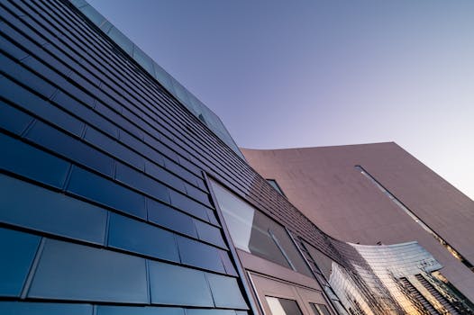 Contemporary building with sleek, reflective facade under a blue sky.