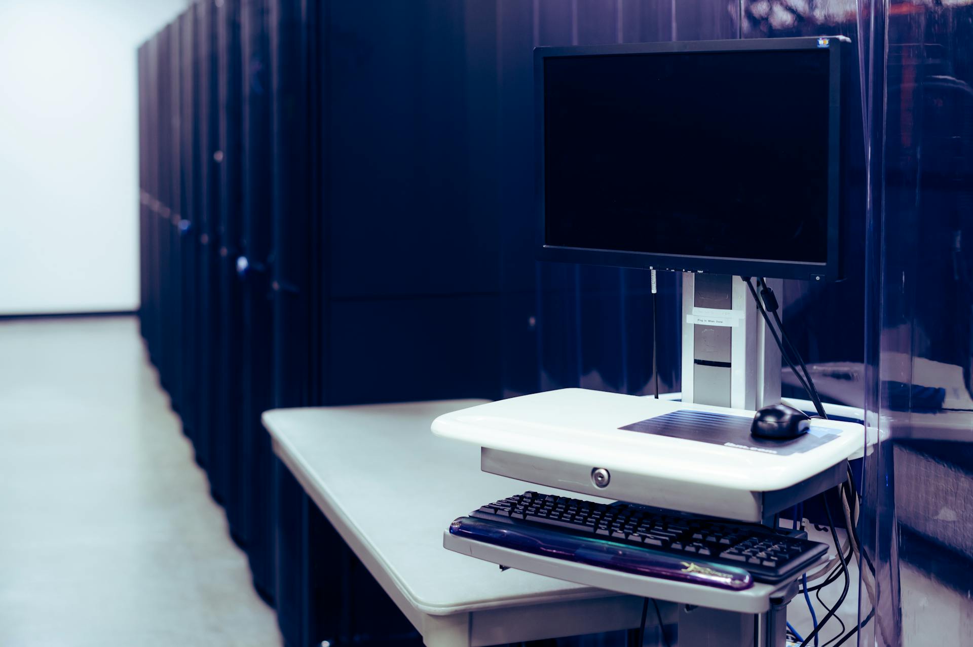 A modern data center featuring a computer setup with monitor and keyboard, emphasizing technology infrastructure.