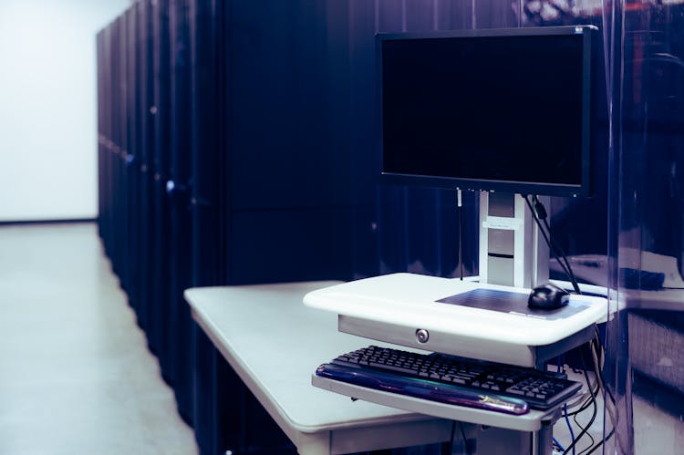 Modern Computer Placed Near Server Racks