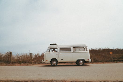 Side view of a classic Volkswagen camper van parked on a scenic road.
