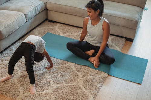 Cheerful mouther and daughter stretching in living room