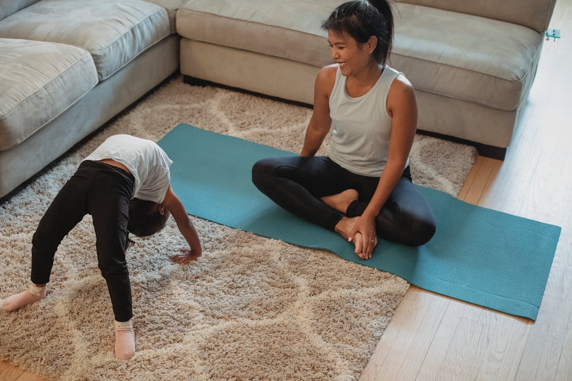 Free Cheerful mouther and daughter stretching in living room Stock Photo